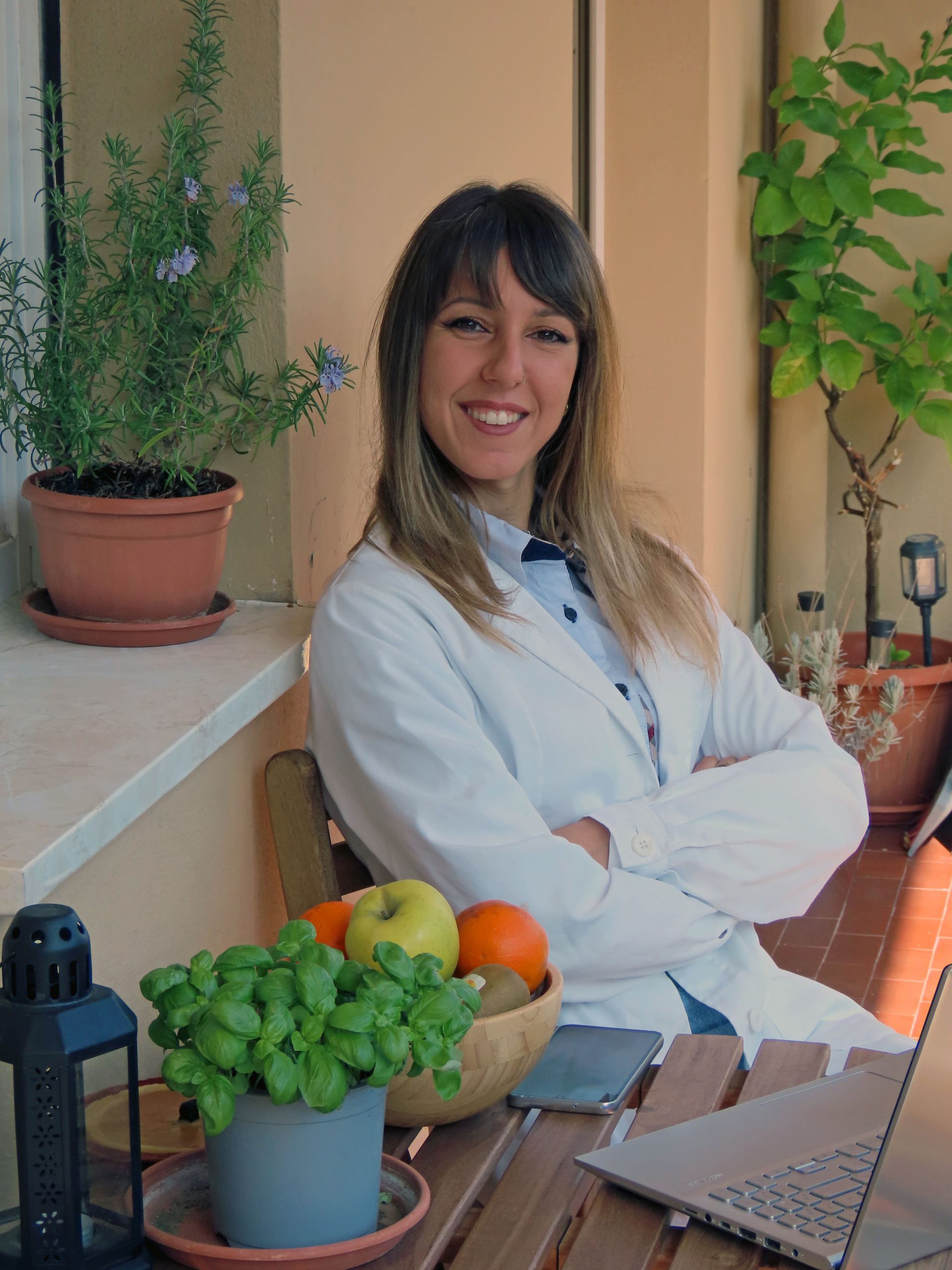 Dott.ssa Elena Ferrari, biologa nutrizionista, ritratto professionale all'aperto con piante aromatiche