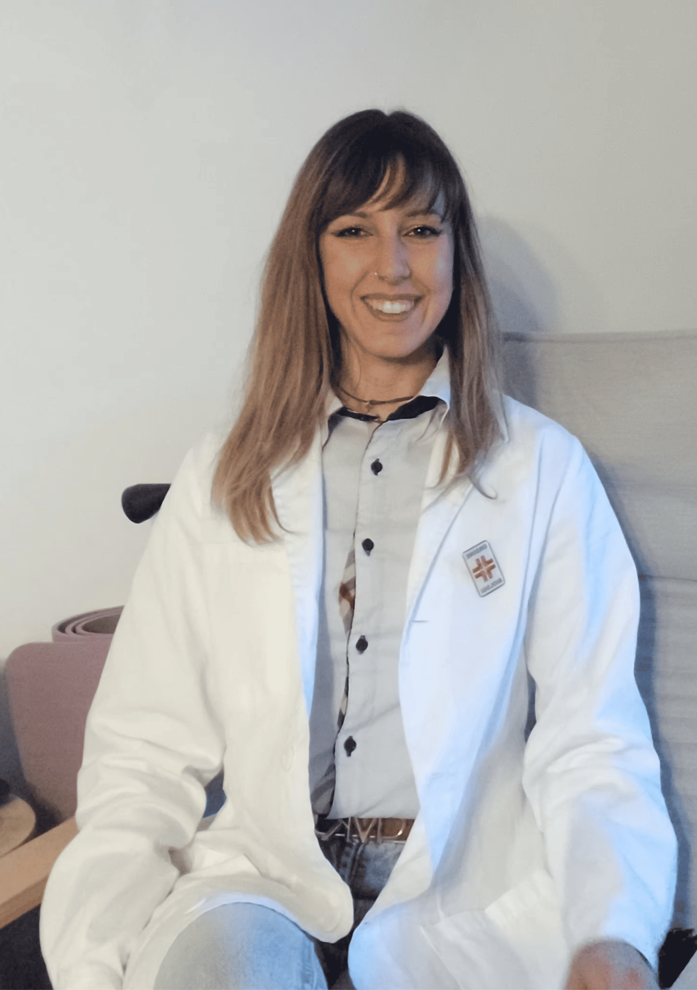 Dott.ssa Elena Ferrari seduta in poltrona nel suo studio, in camice bianco